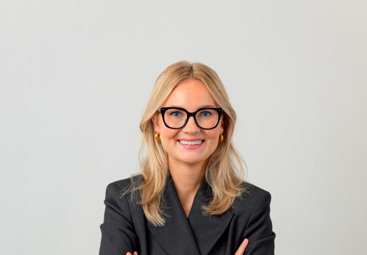 Porträttbild på Ellen Dahl, när hon står med armarna i kors och ler.