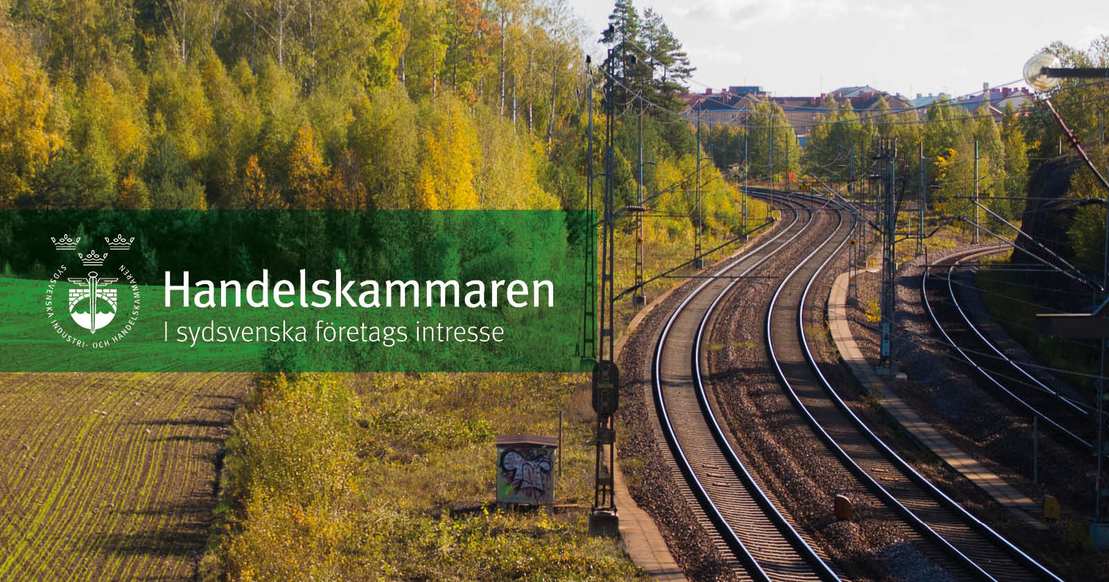 Landskapsbild med tågräls. Till vänster finns en grön ruta med Handelskammarens logga
