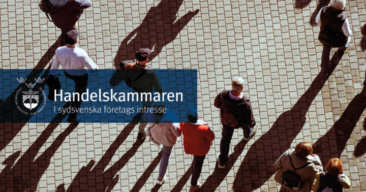 Personer som går över ett torg. Till vänster finns en blå ruta med Handelskammarens logga