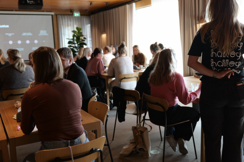 en bild på en workshop som hålls av företaget Hailey. I bilden ser man människor som sitter i konferensrum i grupper som diskuterar.
